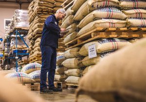 Tim Cole and dozens of bags of green coffee in the warehouse
